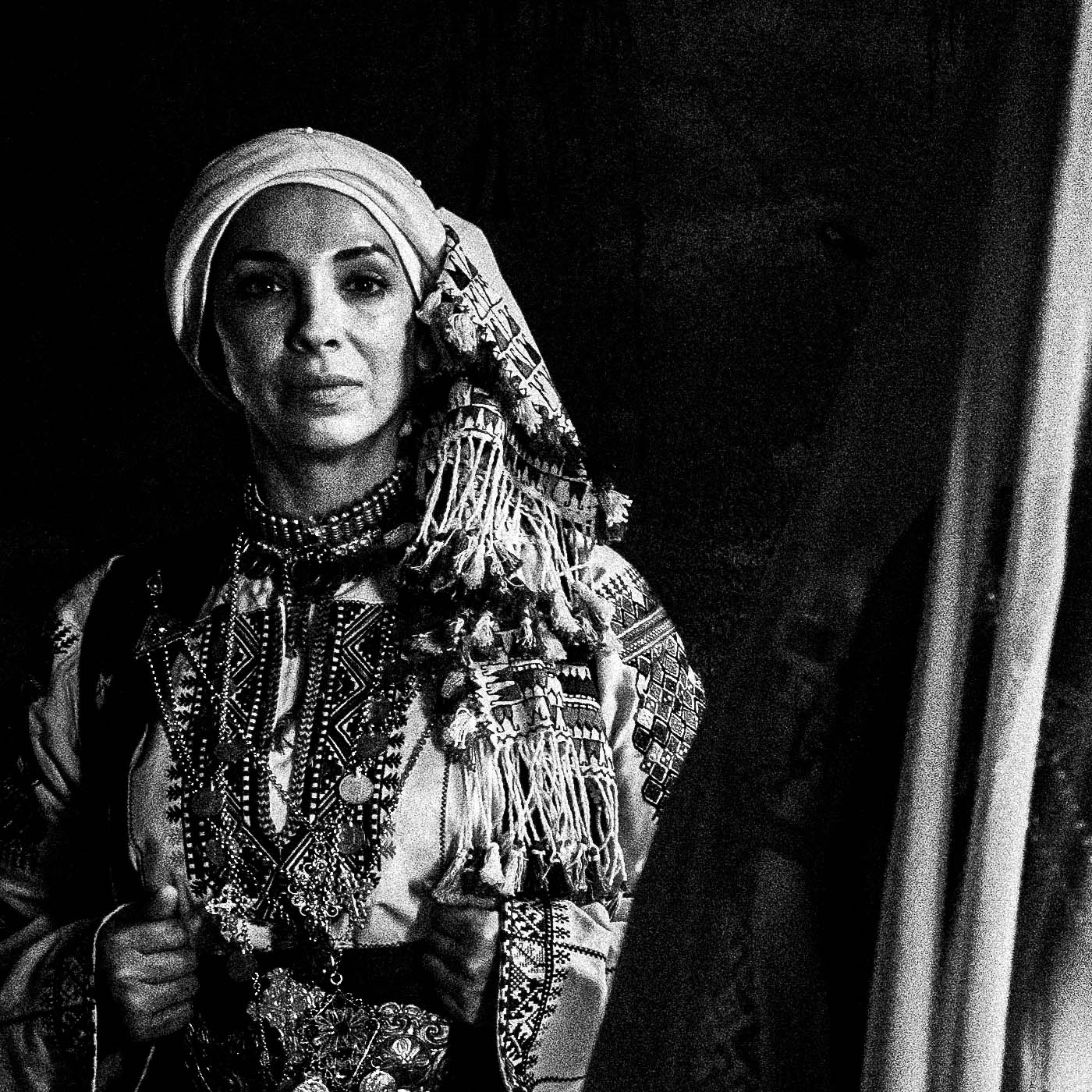 Veiled bride with two supporting figures in Kyparissia local costumes. Peloponnese, Greece. Black and white photography close-up detail by George Tatakis.