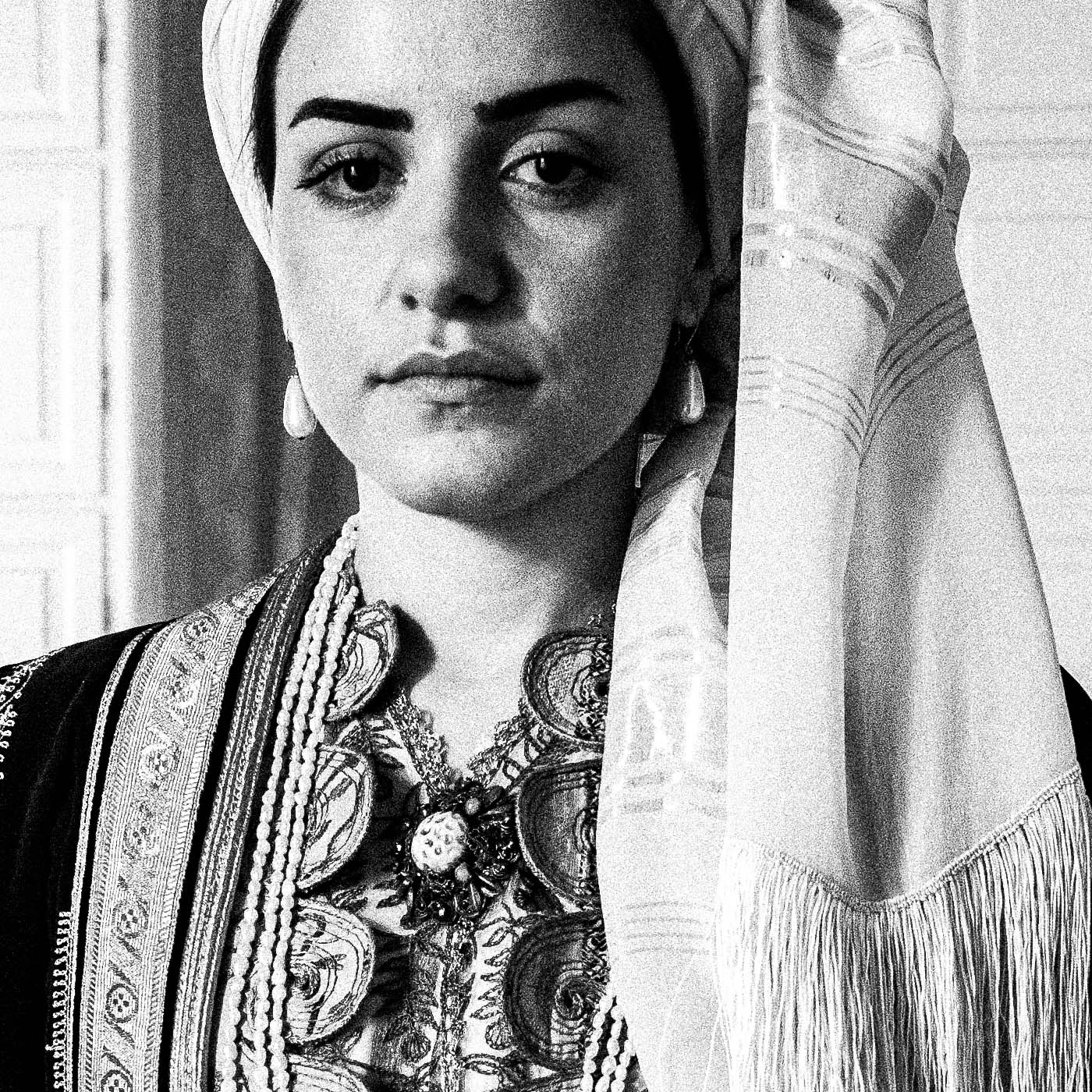Portrait of a woman in the urban dress of Kalamata at the Lyceum Club of Greek Women. Peloponnese, Greece. Black and white photography close-up detail by George Tatakis.
