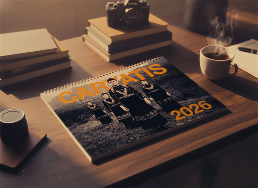 Calendar with 'CARATIS 2026' on a desk with books and a camera