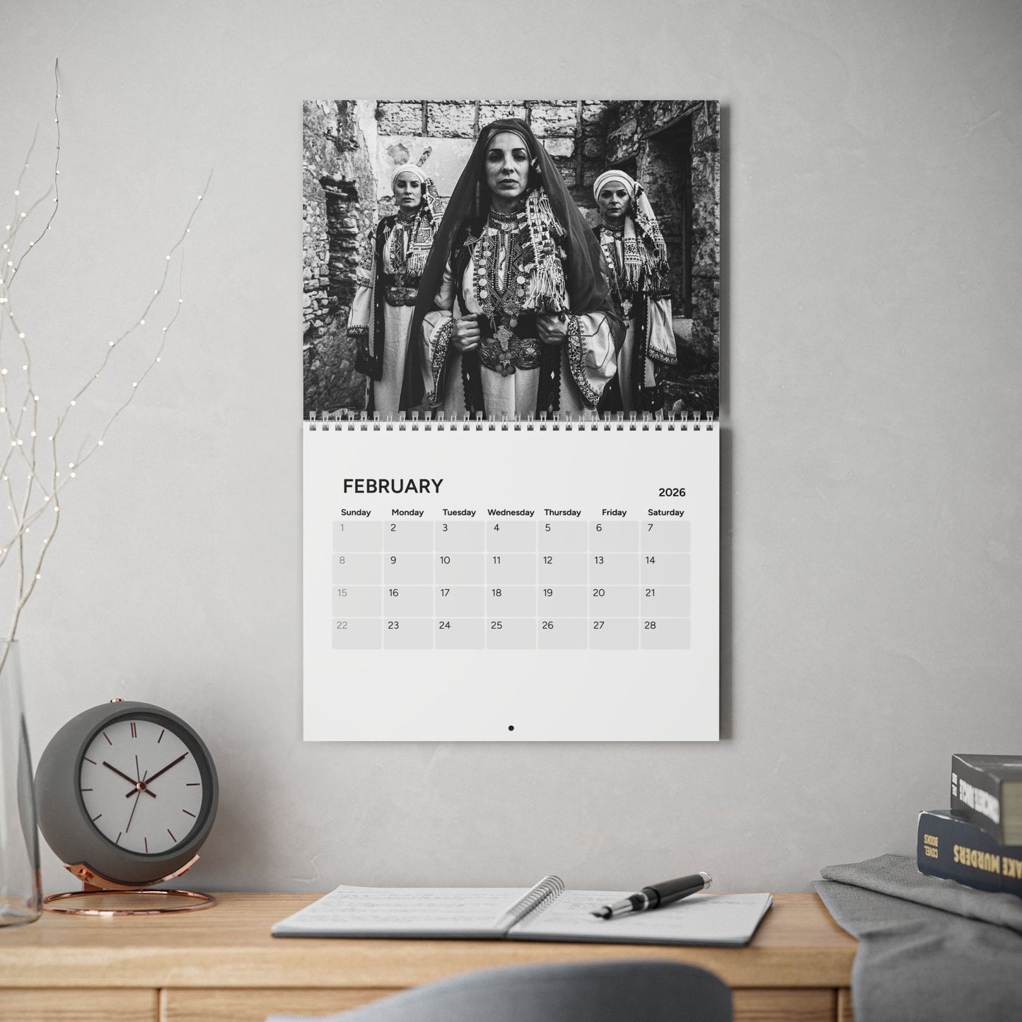Calendar on a wall with a black and white photo of three women in traditional attire.