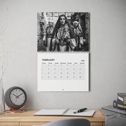 Calendar on a wall with a black and white photo of three women in traditional attire.