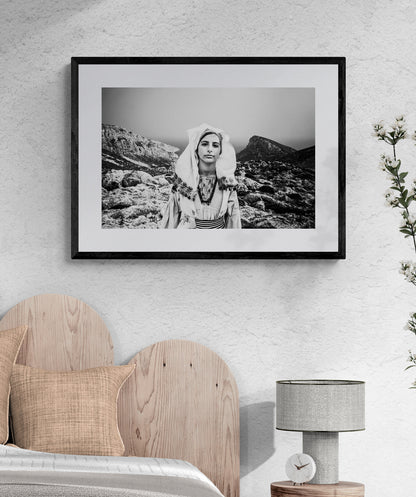 Black and White Photography Wall Art Greece | Girl wearing the traditional costume of Tilos island at a windy cliff Dodecanese Greece by George Tatakis - single framed photo