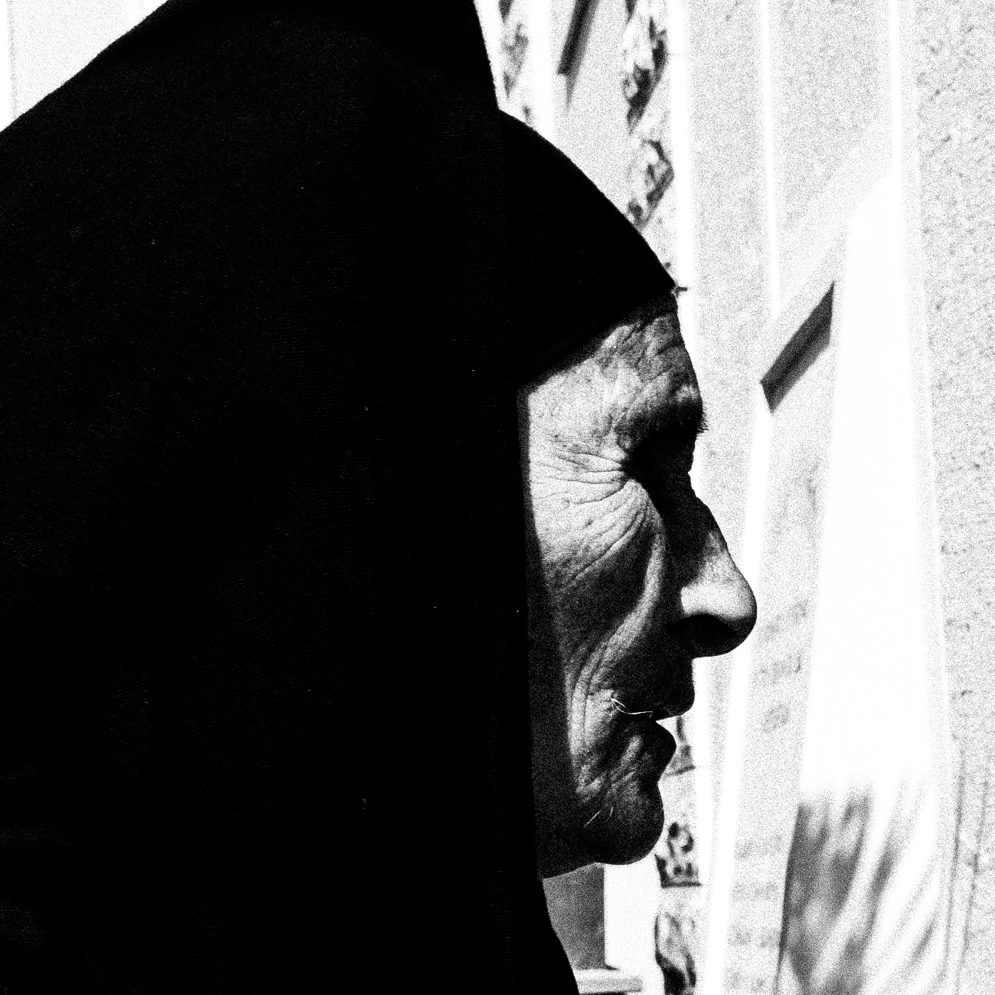 Black and White Photography Wall Art Greece | Woman entering the church Olympos Karpathos Dodecanese by George Tatakis - detailed view