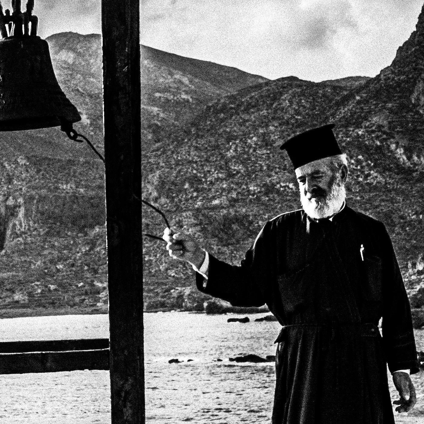 Black and White Photography Wall Art Greece | Priest striking the bell at St. John celebration in Vrykounta Olympos Karpathos Dodecanese by George Tatakis - detailed view
