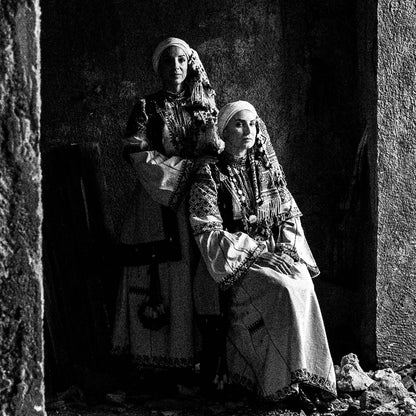 Woman in profile and two supporting figures in Kyparissia costumes, Peloponnese, Greece. Black and white photography close-up detail by George Tatakis.