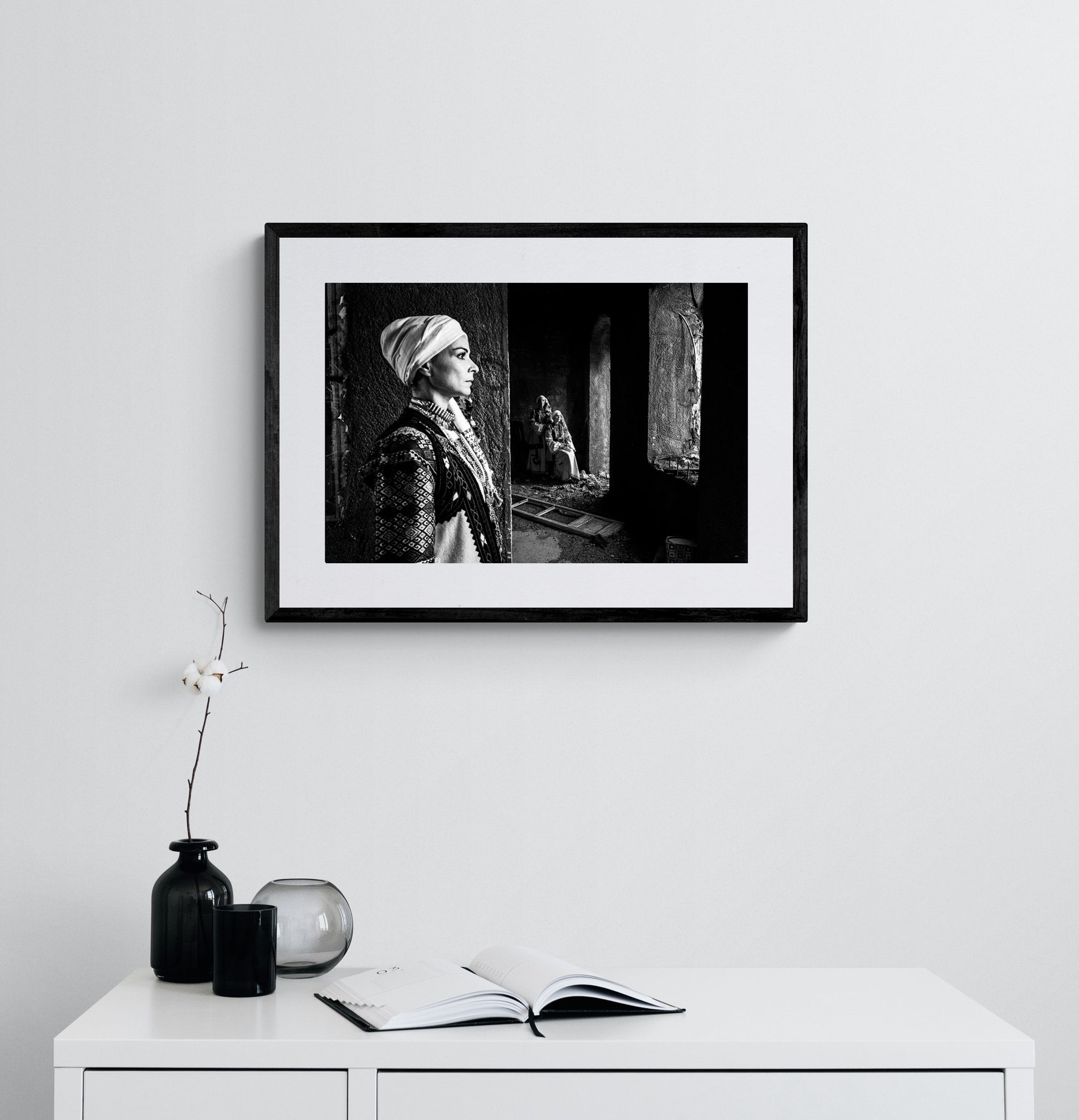 Woman in profile and two supporting figures in Kyparissia costumes, Peloponnese, Greece. Black and white photography framed on a wall by George Tatakis.