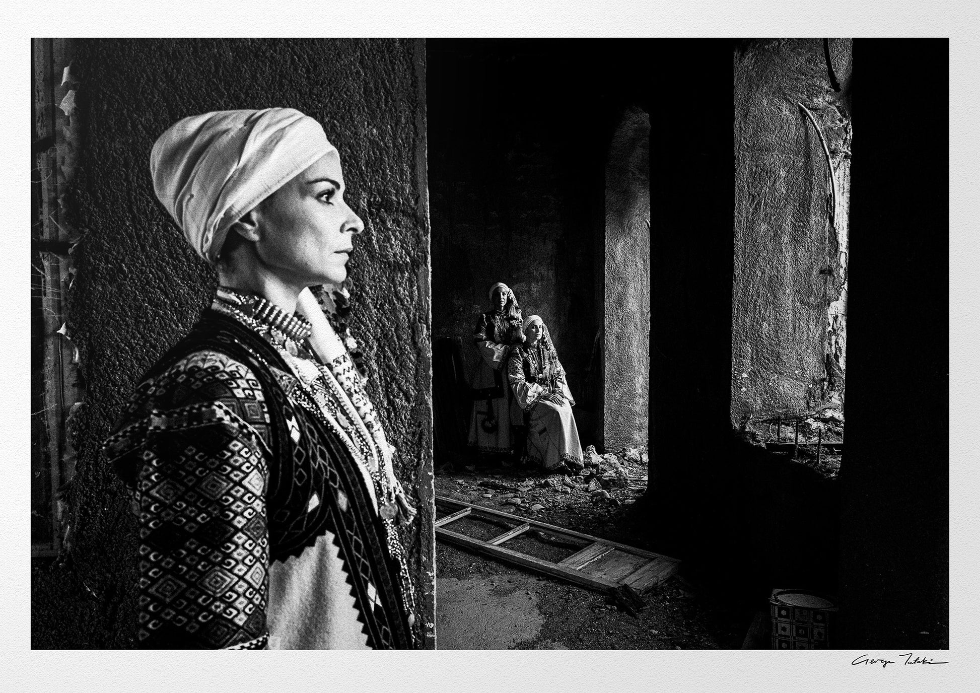 Woman in profile and two supporting figures in Kyparissia costumes, Peloponnese, Greece. Black and white photography by George Tatakis.