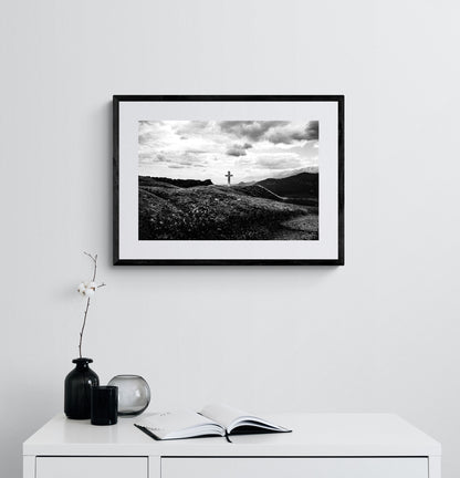 Cross on a rock at Meteora. Black-and-white photography artwork by George Tatakis from the project Chorōs. Framed on a white wall