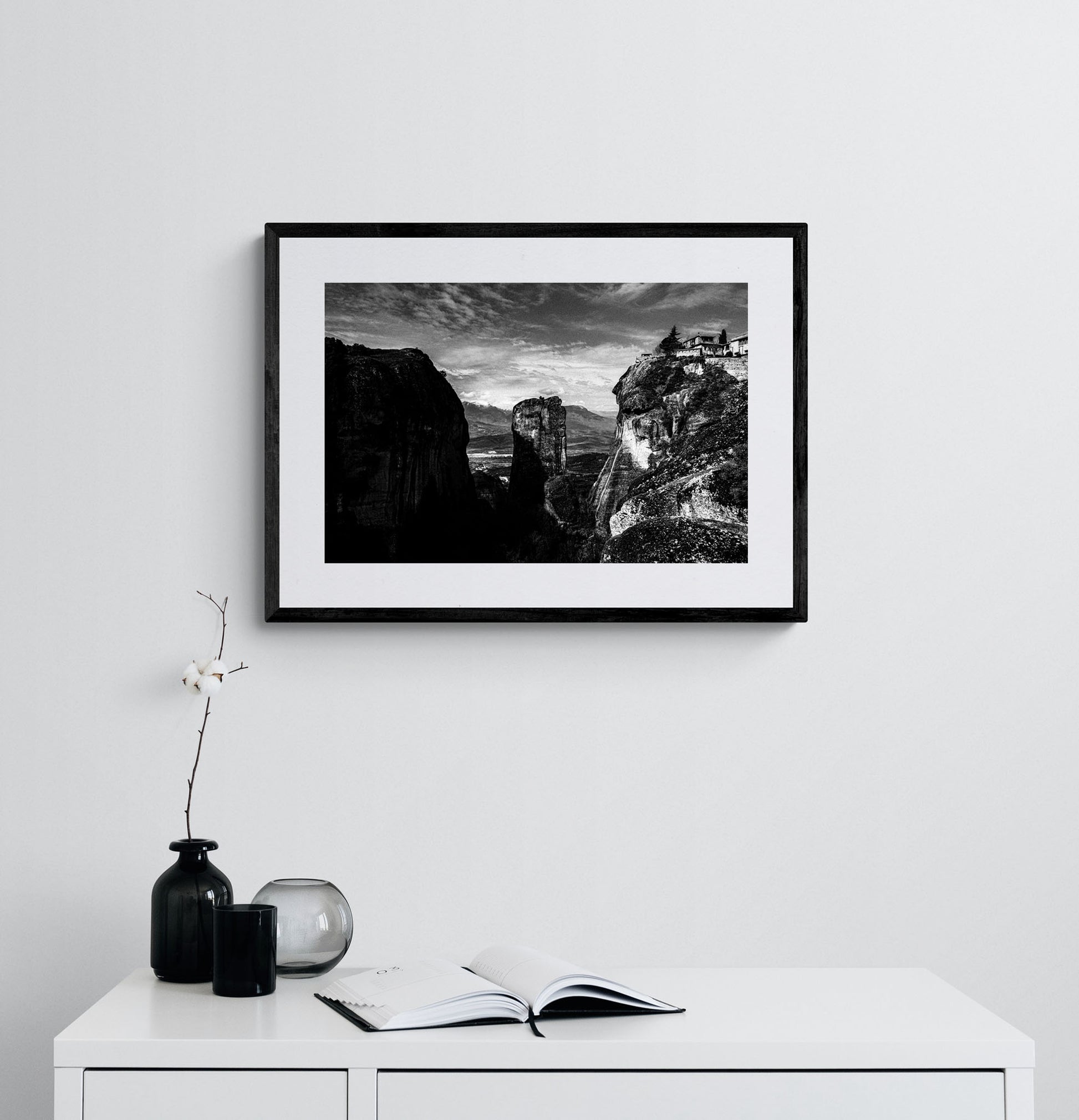 Rock pillars at Meteora. Black-and-white photography print by George Tatakis from the project Chorōs. Framed atwork on a white wall