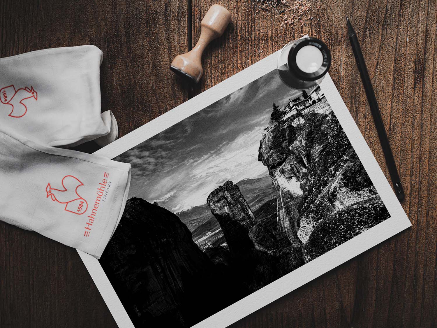 Rock pillars at Meteora. Black-and-white photography print by George Tatakis from the project Chorōs. Print on a wooden table