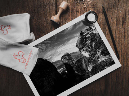 Rock pillars at Meteora. Black-and-white photography print by George Tatakis from the project Chorōs. Print on a wooden table