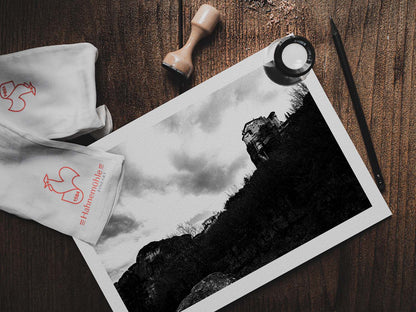 Monastery at Meteora (Roussanou). Black-and-white photography artwork by George Tatakis from the project Chorōs. Print on a wooden table