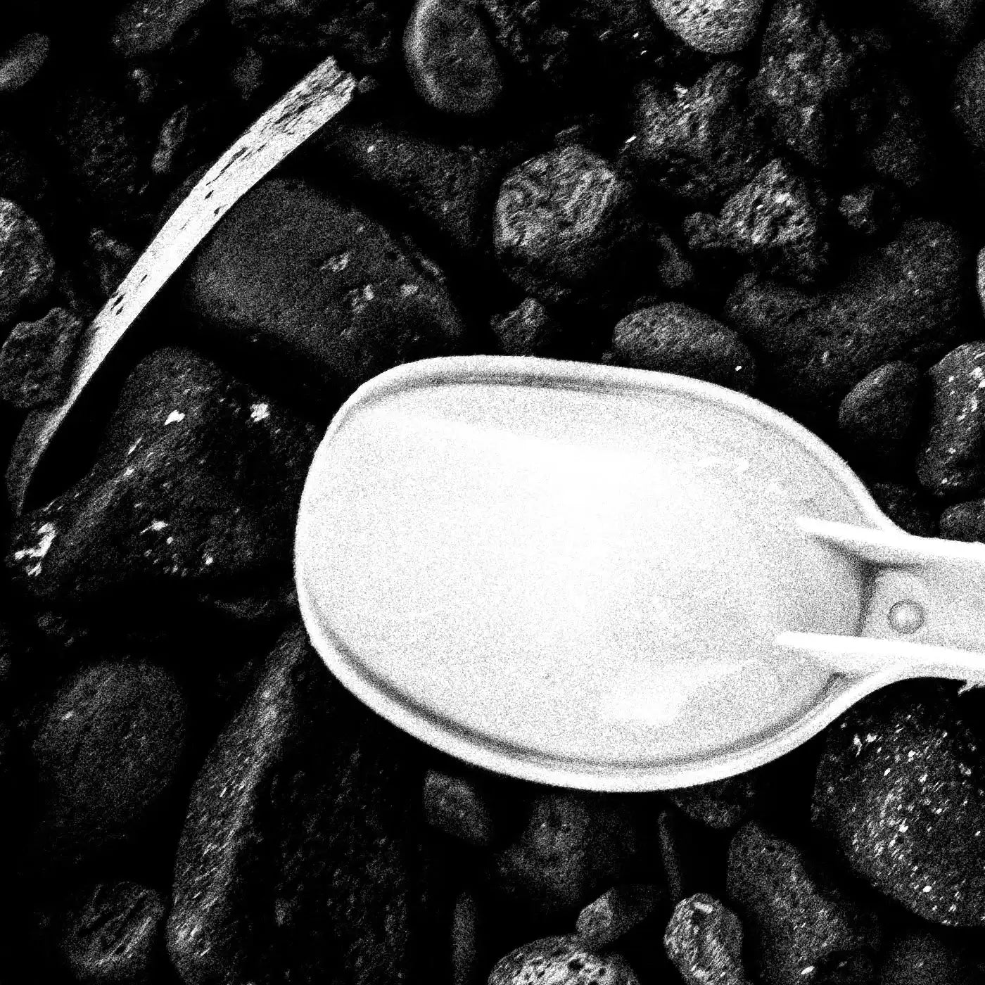 Black Pebbles and Shovel | Santorini | Chorōs | Black-and-white wall art photography from Greece - detailed view