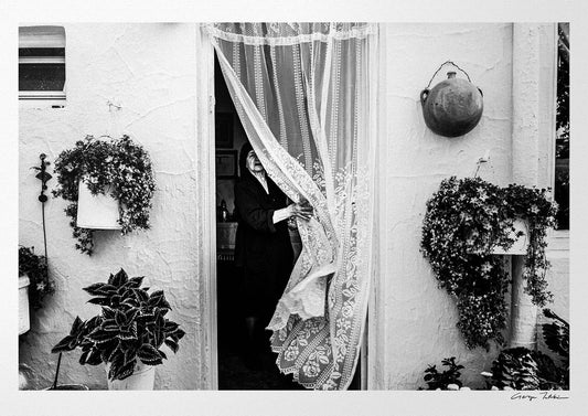 Black and White Photography Wall Art Greece | Lady in Anogia behind a curtain Crete by George Tatakis