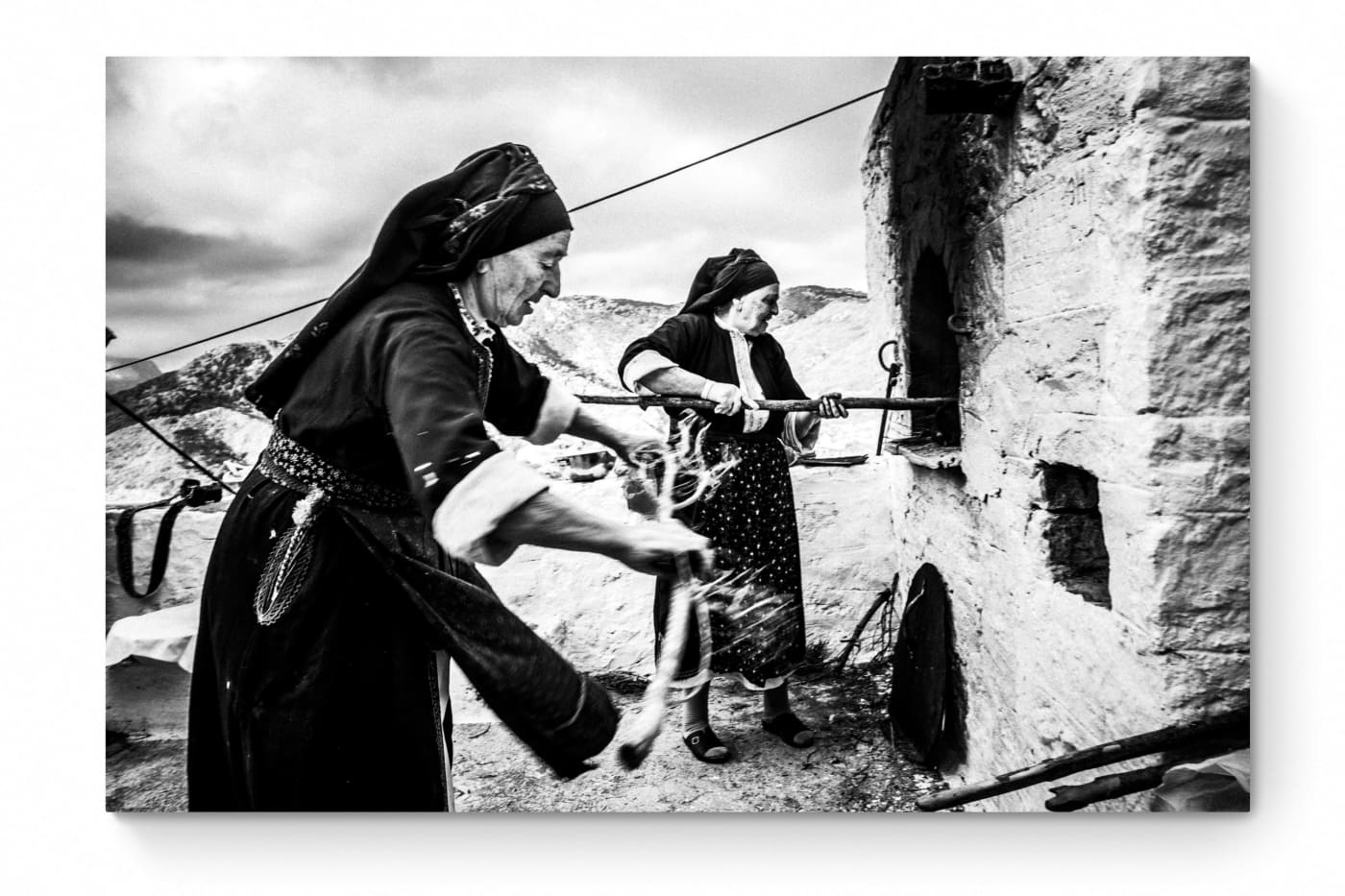 Black and White Photography Wall Art Greece | Women lighting up the wood oven Olympos Karpathos Dodecanese by George Tatakis - whole photo