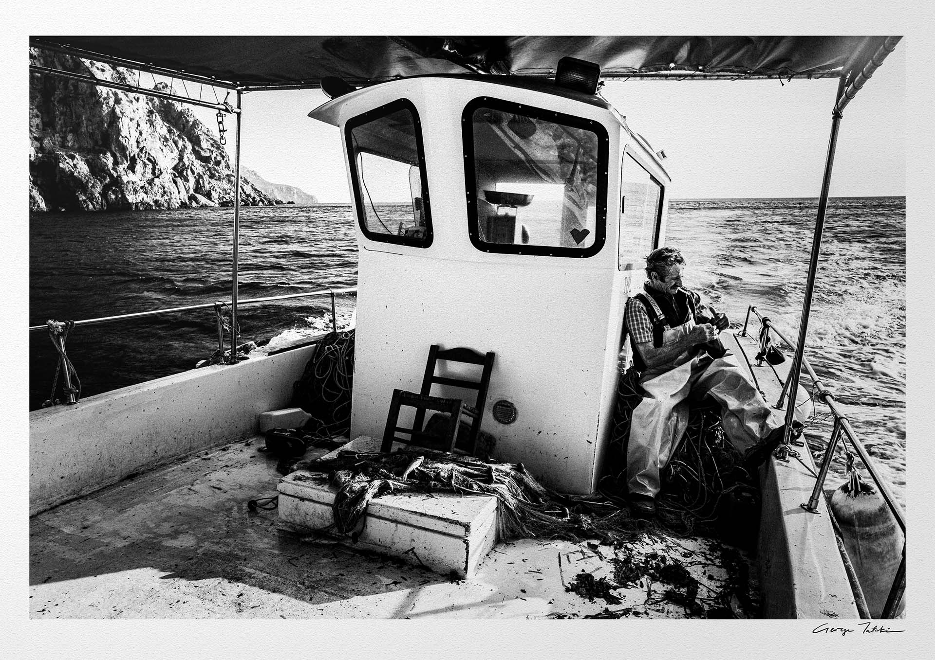 Black and White Photography Wall Art Greece | Fisherman smoking on his boat in Diafani Olympos Karpathos Dodecanese by George Tatakis