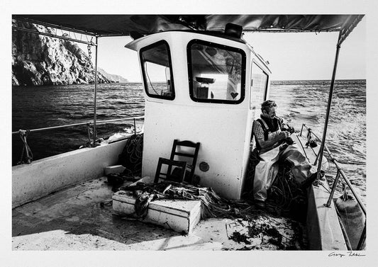 Black and White Photography Wall Art Greece | Fisherman smoking on his boat in Diafani Olympos Karpathos Dodecanese by George Tatakis