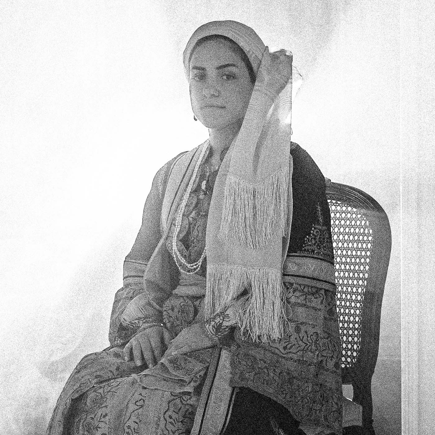 Sitting portrait of a woman in the urban costume of Kalamata, shot at the Lyceum Club of Greek Women. Peloponnese, Greece. Black and white photography close-up detail by George Tatakis.