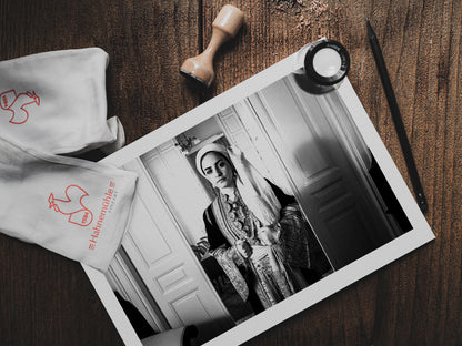 Portrait of a woman in the urban dress of Kalamata at the Lyceum Club of Greek Women. Peloponnese, Greece. Black and white photography print on a table by George Tatakis.
