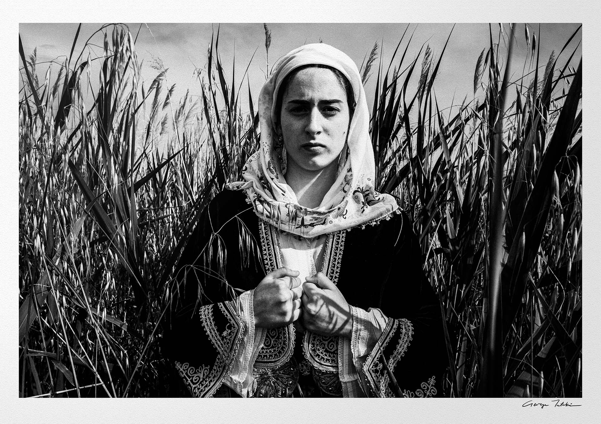 Black and White Photography Wall Art Greece by George Tatakis | A woman in the costume of Kymi in a field of straws, Euboea island