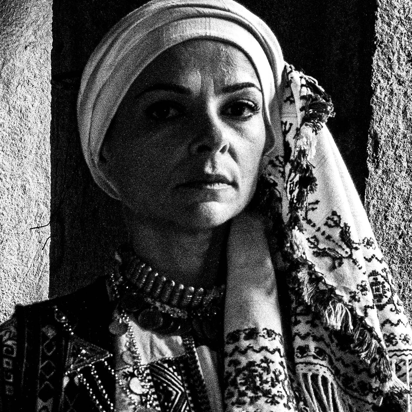 Veiled bride and two women in Kyparissia costumes, Peloponnese, Greece. Black and white photography close-up detail by George Tatakis.