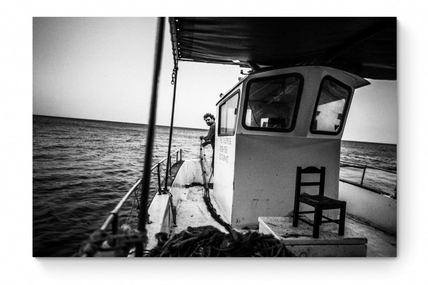 Black and White Photography Wall Art Greece | Fisherman with nets on his boat in Diafani Olympos Karpathos Dodecanese by George Tatakis - whole photo
