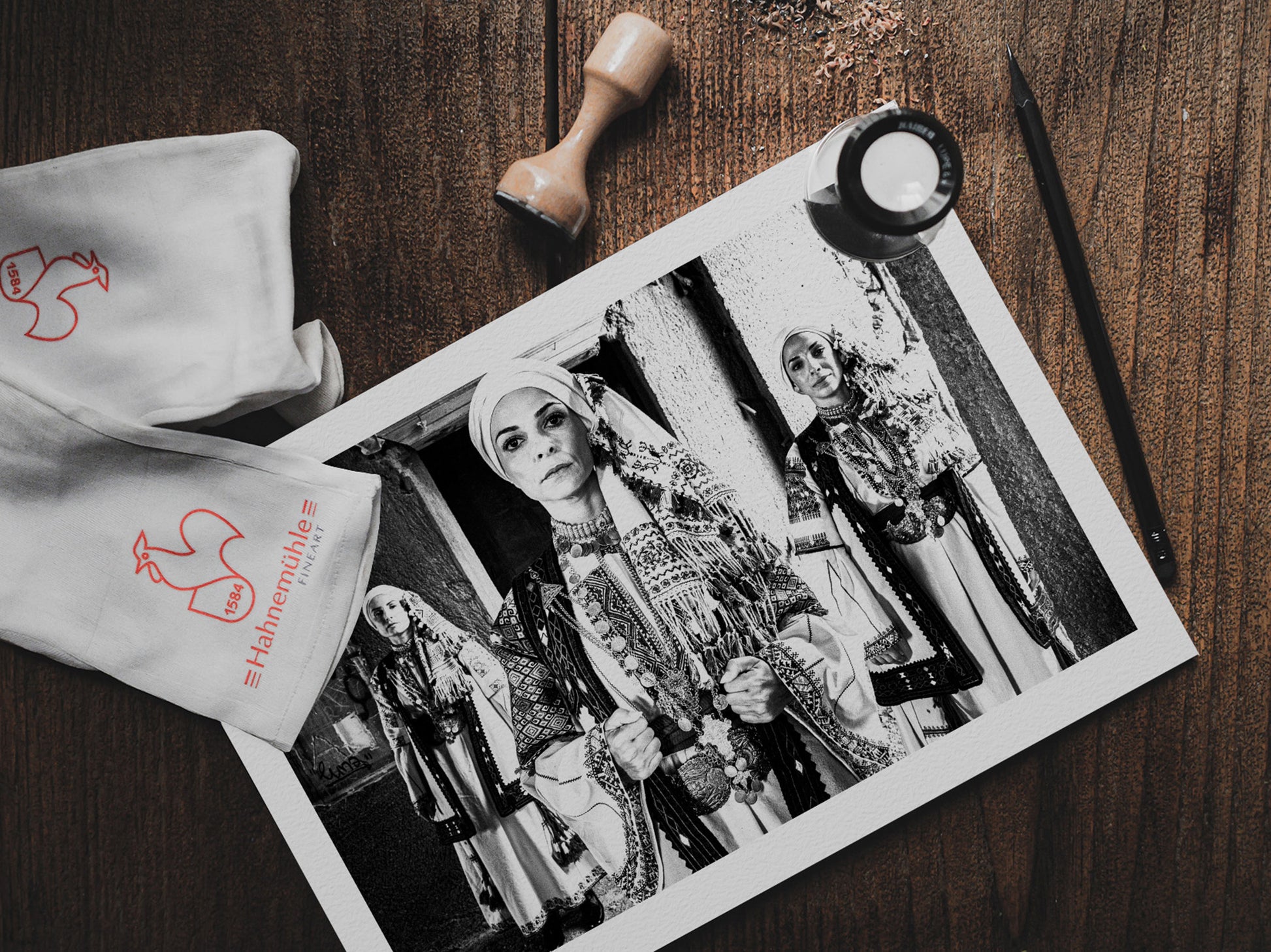 Three women in traditional attire standing in a doorway. Kyparissia, Peloponnese, Greece. Black and white photography print on table by George Tatakis.