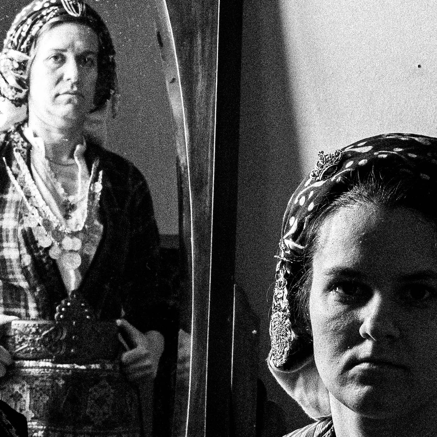 A group of women with a mirror wearing the local costumes of Soufli, Thrace, Greece. Black and white photography close-up detail by George Tatakis.