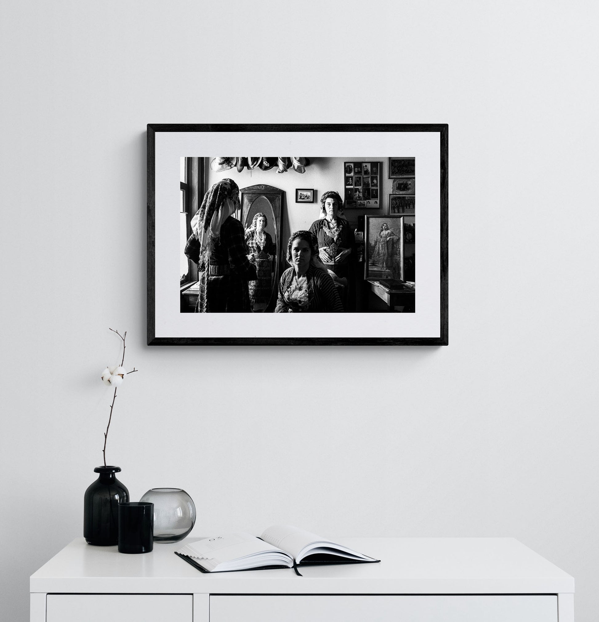 A group of women with a mirror wearing the local costumes of Soufli, Thrace, Greece. Black and white photography framed on a wall by George Tatakis.