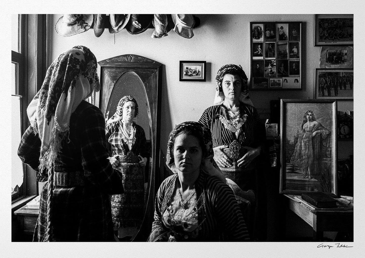 A group of women with a mirror wearing the local costumes of Soufli, Thrace, Greece. Black and white photography by George Tatakis.