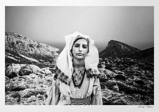 Black and White Photography Wall Art Greece | Girl wearing the traditional costume of Tilos island at a windy cliff Dodecanese Greece by George Tatakis