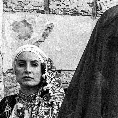 Three women in traditional attire standing in stone-walled ruins. Kyparissia, Peloponnese, Greece. Black and white photography close-up detail by George Tatakis.