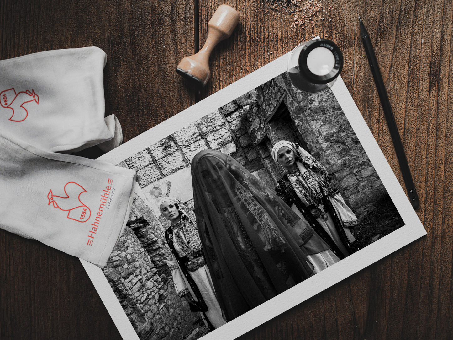 Three women in traditional attire standing in stone-walled ruins. Kyparissia, Peloponnese, Greece. Black and white photography print on table by George Tatakis.